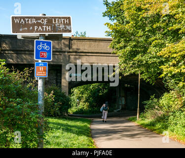 Wasser des Leith Fußweg und Radweg Schild mit Frau gehen unter der Brücke am sonnigen Tag Leith, Edinburgh, Schottland, Großbritannien Stockfoto