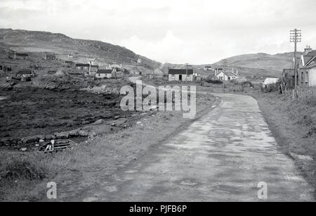 1950er Jahre, historische Bild mit einem kleinen abgelegenen ländlichen Siedlung auf den Äußeren Hebriden, Western Isles, Schottland, Großbritannien, mit einem schmal leere Straße und ein paar Einstöckige crofters Cottages. Stockfoto