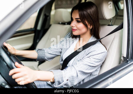 Portrait von lächelnden Fahrer ihr Gurt befestigen, bevor sie Auto fahren. Stockfoto