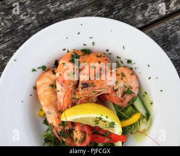 Auf der Suche nach unten von oben auf eine Fischplatte mit frischen Garnelen, Salat und Beilagen in einem gesunden Mittagessen Zeit Mahlzeit Stockfoto