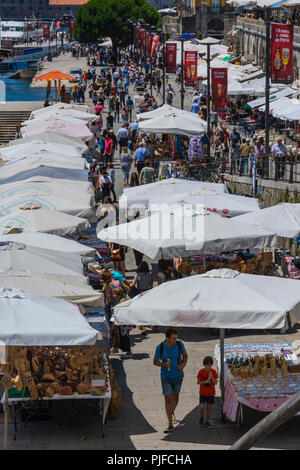 PORTO, PORTUGAL - 21. JULI 2017: Menschen, die in der Nachbarschaft von Ribeira, am Douro-Fluss, eine belebte Gegend voller Barterrassen und Straßenverkäufern zu Fuß gehen Stockfoto