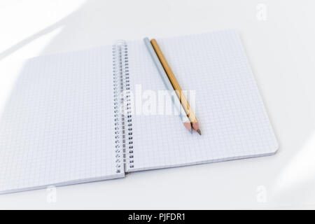 Notebook, silber und gold Bleistift auf weißem Hintergrund Stockfoto