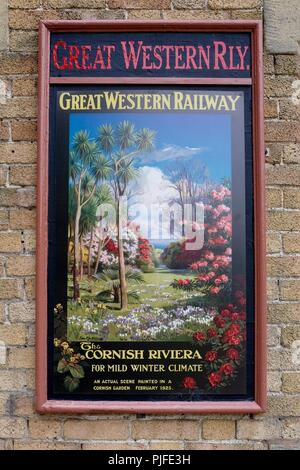 In der Nähe der bunten vintage Great Western Railway Plakat für die Cornish Riviera mit üppiger Vegetation Förderung des milden Winters auf der Mauer Stockfoto