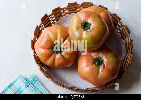 Organic grosse Tomaten in Holz- Korb. Ökologische Lebensmittel. Stockfoto