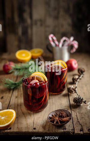 Wein mit Gewürzen in Glas auf rustikalen Tabelle tabelle Glühwein. Weihnachten Lebensmittel Konzept. Nahaufnahme Stockfoto