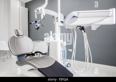 Medizin, Zahnmedizin, Dental Clinic office, medizinische Geräte und Instrumente für die Zahnmedizin - Zahnmedizin, grau Stuhl, Mikroskop Stockfoto