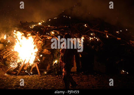 Ein Mann vor einem brennenden Feuer während der Nacht am Lagerfeuer feiern am 5. November in Littlehampton, West Sussex, UK. Stockfoto