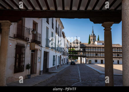 Tembleque, Spanien, ist ein kleines Dorf mit einer Kirche und einem Uhrenturm im Zentrum, das an einem Sommertag ohne Wolken am Himmel fotografiert wurde. Stockfoto