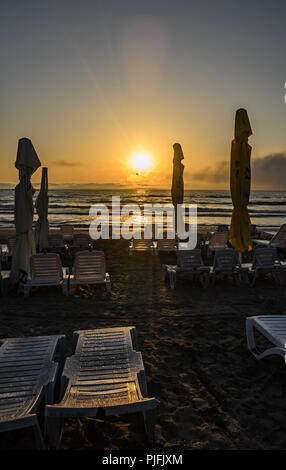 MAMAIA, Rumänien - 15. SEPTEMBER 2017: Sonnenliegen am Strand des Schwarzen Meeres bei Sonnenaufgang, warme Momente. Stockfoto