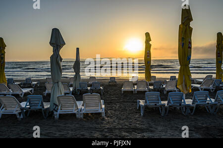 MAMAIA, Rumänien - 15. SEPTEMBER 2017: Sonnenliegen am Strand des Schwarzen Meeres bei Sonnenaufgang, warme Momente. Stockfoto