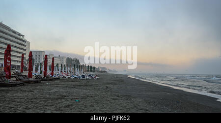 MAMAIA, Rumänien - 15. SEPTEMBER 2017: Strand des Schwarzen Meeres von Mamaia, Rumänien mit Sonnenliegen und Sonnenschirmen, nebligen Tag. Stockfoto