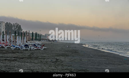 MAMAIA, Rumänien - 15. SEPTEMBER 2017: Strand des Schwarzen Meeres von Mamaia, Rumänien mit Sonnenliegen und Sonnenschirmen, nebligen Tag. Stockfoto