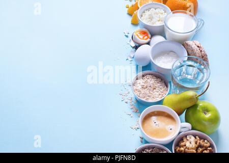 Nützliche bunten Frühstück Kaffee Milch Tee Früchte Quark Hafer Flach Still Life Table Top Anzeigen blauer Hintergrund Stockfoto