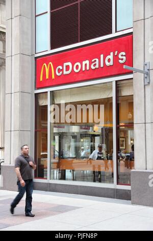 CHICAGO, USA - 26. JUNI 2013: Person Wanderungen von McDonald's Restaurant in Chicago. McDonald's ist die 2 erfolgreichsten Restaurant Franchise in der WORL Stockfoto