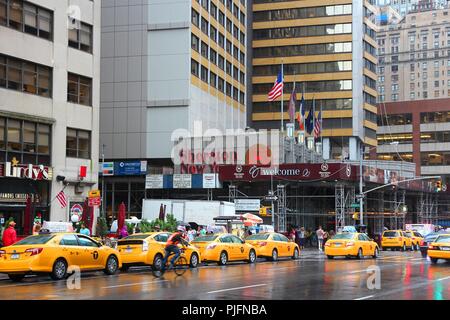 NEW YORK, USA - Juli 1, 2013: die Menschen zu Fuß entlang dem Taxi 7. Avenue in New York. Ab 2012 waren 13,237 gelbe Taxis in New Y registriert Stockfoto