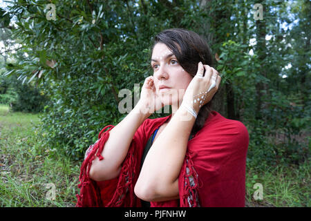 Junge Hippie schöne Brünette Frau Modell mit langen Zopf Haar weiß tribal Make-up in der Ferne weit weg suchen Stockfoto