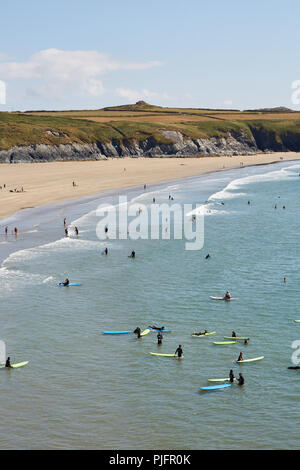 Hohe Sicht des Menschen beim Lernen zu Surfen im Meer bei Whitesands Bay in Pembrokeshire Wales an der Südküste an einem sonnigen blauen Himmel Tag Stockfoto