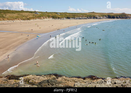 Hohe Sicht des Menschen beim Lernen zu Surfen im Meer bei Whitesands Bay in Pembrokeshire Wales an der Südküste an einem sonnigen blauen Himmel Tag Stockfoto