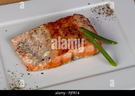 Gebratenes Lachssteak serviert grüne Zwiebel Stockfoto