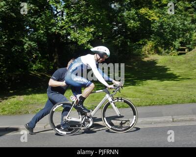 Als Mitglied im Team ein Pro ist nach einem Fahrrad ändern gedrückt. Tour durch Großbritannien 2018, Cockermouth, Cumbria, England, Vereinigtes Königreich Stockfoto