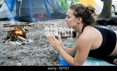 Portrait ot einer jungen Frau mit Namaste Gebet pose Hände toguether Yoga beim camping im Wald Stockfoto