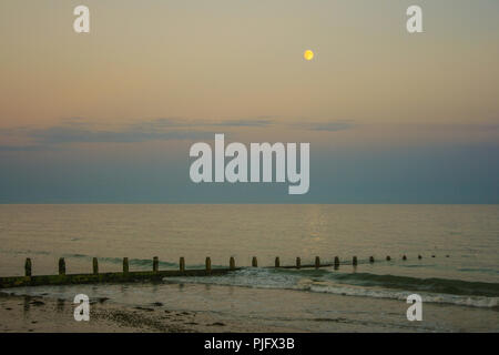 Mond über dem Strand steigende Stockfoto