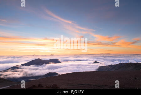 Eine flammende Morgen Sonne über eine Verkleidung von Wolken in den Krater des Haleakala, einem schlafenden Vulkan auf der Insel Maui, Hawaii Stockfoto