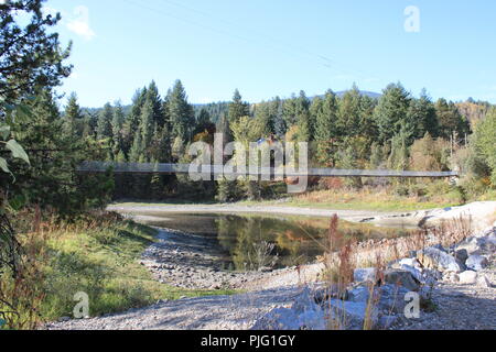 Fußgänger-Hängebrücke über den Fluss im Herbst Stockfoto