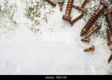 Rostige Schrauben Muster. alte Stahl Schrauben auf Grunge weiß Holz Hintergrund Ansicht von oben mit der Kopie. Stockfoto