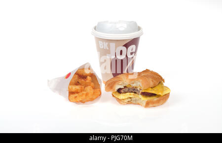 Burger King Frühstück mit Kaffee, Wurst, Ei und Käse croissan', oder Croissant Sandwich und Hash Brown Kartoffeln Stockfoto