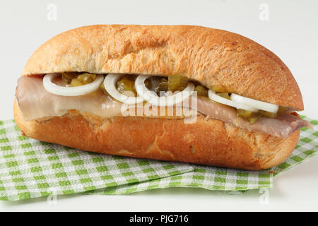 Niederländische Hering Sandwich mit Essiggurken und Zwiebeln Stockfoto