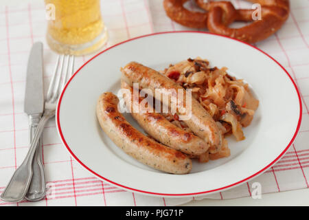 Bayerische Würstchen gegrillt, geschmort Kohl mit Pilzen, und ein Glas Bier Stockfoto