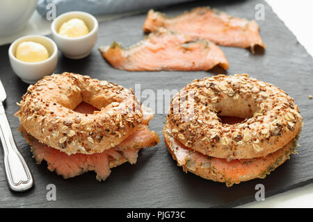 Lachs Bagel Sandwiches auf einer Schiefertafel Schneidebrett Stockfoto