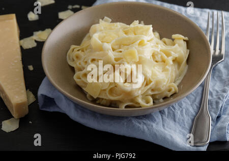 Fettuccine Alfredo mit Parmesan Käse auf einem rustikalen Tisch Stockfoto