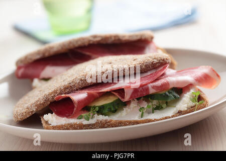 Sandwiches mit weichem Käse, in Scheiben geschnittene Gurke und Schinken Stockfoto