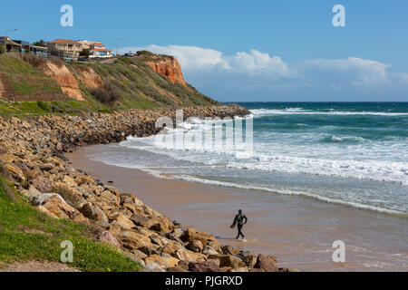 Ein Surfer entlang der Sand im Wasser bei Christies Beach South Australia am 6. September 2018, Stockfoto