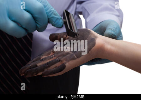 Der Polizist nimmt Fingerabdrücke von den Verdächtigen. Untersuchung der Kriminalität. Stockfoto