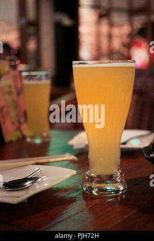 Zwei Gläser Bier auf dem Tisch liegen, bevor einige von Lebensmitteln in einem Restaurant serviert. Stockfoto