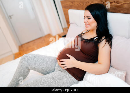 Schmerzliche Ausdruck auf schwangeren Frau Gesicht Stockfoto