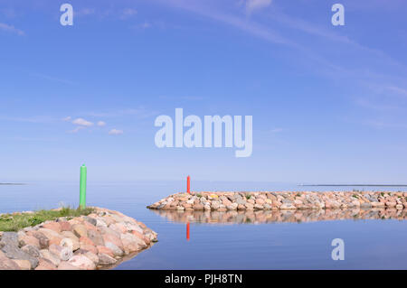 Kleiner Hafen, alte Pier von Steinen in der Insel Saaremaa Estland. Ostsee, Europa. Anschluss Saaremaas an einem sonnigen Tag. Zwei kleine Anlegestelle für kleine Boote. Stockfoto