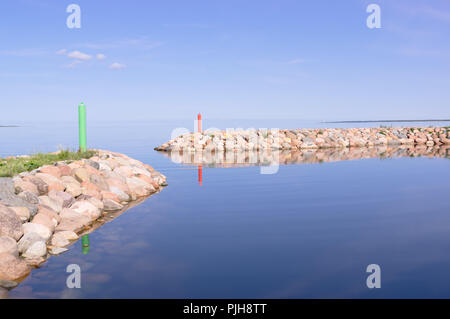 Kleiner Hafen, alte Pier von Steinen in der Insel Saaremaa Estland. Ostsee, Europa. Anschluss Saaremaas an einem sonnigen Tag. Zwei kleine Anlegestelle für kleine Boote. Stockfoto