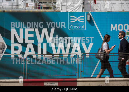 Londoner Pendler Spaziergang, vorbei an den Anschlagtafeln der Förderung der Crossrail Neue Queen Elizabeth rail line, der Hauptstadt neueste am 3. September 2018, auf Moorgate in London, England. Die Crossrail Elizabeth Line ist ein 118-Kilometer (73-Meile) Bahnstrecke unter Entwicklung in London und der Grafschaften Berkshire, Buckinghamshire und Essex, England. Crossrail ist der größte Bauprojekt in Europa und ist eine der größten Investitionen in die Infrastruktur, die jemals in Großbritannien durchgeführt - ein £ 15 Mrd. transport Projekt, wurde im Dezember 2018 zu öffnen, aber jetzt auf den Herbst 2019 verschoben. Stockfoto