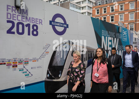 Londoner Pendler Spaziergang, vorbei an den Anschlagtafeln der Förderung der Crossrail Neue Queen Elizabeth rail line, der Hauptstadt neueste am 3. September 2018, auf Moorgate in London, England. Die Crossrail Elizabeth Line ist ein 118-Kilometer (73-Meile) Bahnstrecke unter Entwicklung in London und der Grafschaften Berkshire, Buckinghamshire und Essex, England. Crossrail ist der größte Bauprojekt in Europa und ist eine der größten Investitionen in die Infrastruktur, die jemals in Großbritannien durchgeführt - ein £ 15 Mrd. transport Projekt, wurde im Dezember 2018 zu öffnen, aber jetzt auf den Herbst 2019 verschoben. Stockfoto