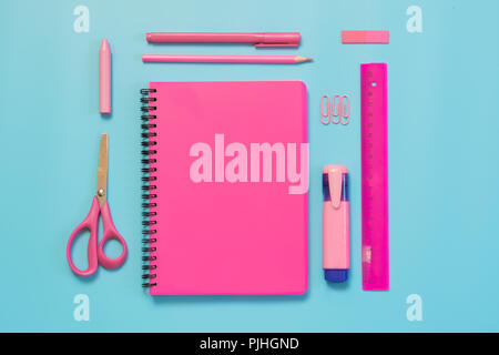 Rosa mädchenhafte Schulmaterial, Hefte und Stifte auf druckvolle Blau. Ansicht von oben, flach. Kopieren Sie Platz. Stockfoto