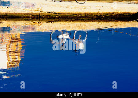 Riflesso in Mare di una bici lasciata sul Molo di Mola Di Bari Stockfoto