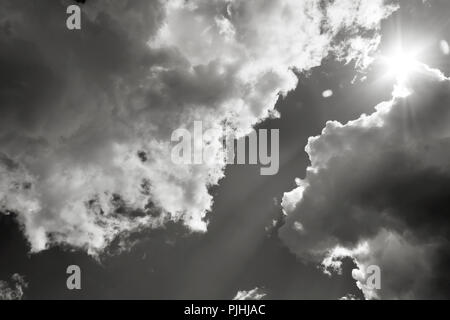 Die Sonne bricht durch die Wolken. Schwarz und Weiß Foto Stockfoto