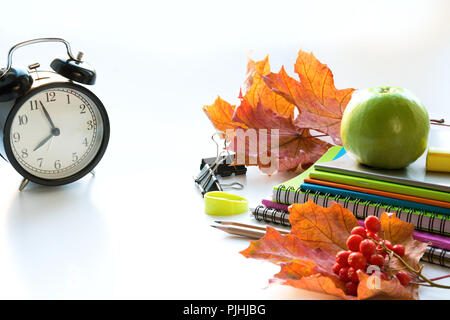 Bunte Schulmaterial, Buch und Wecker auf Weiß. Ansicht von oben, flach. Ansicht von oben, kopieren. Zurück zu Schule. Stockfoto
