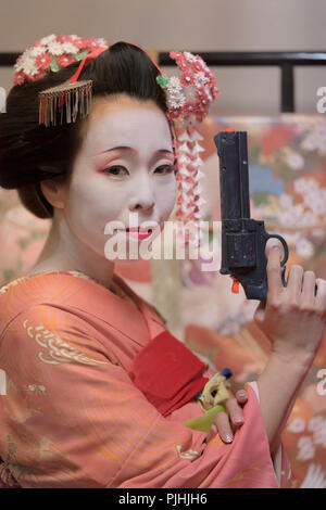 Maiko im Kimono Holding eine Waffe in der Hand. Stockfoto