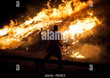 Ein Mann vor einem brennenden Feuer während der Nacht am Lagerfeuer feiern am 5. November in Littlehampton, West Sussex, UK. Stockfoto