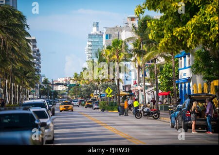MIAMI, USA - ca. Juli 2018: Am frühen Morgen Blick hinunter Ocean Drive mit Palmen und Art déco-Hotel in South Beach. Stockfoto